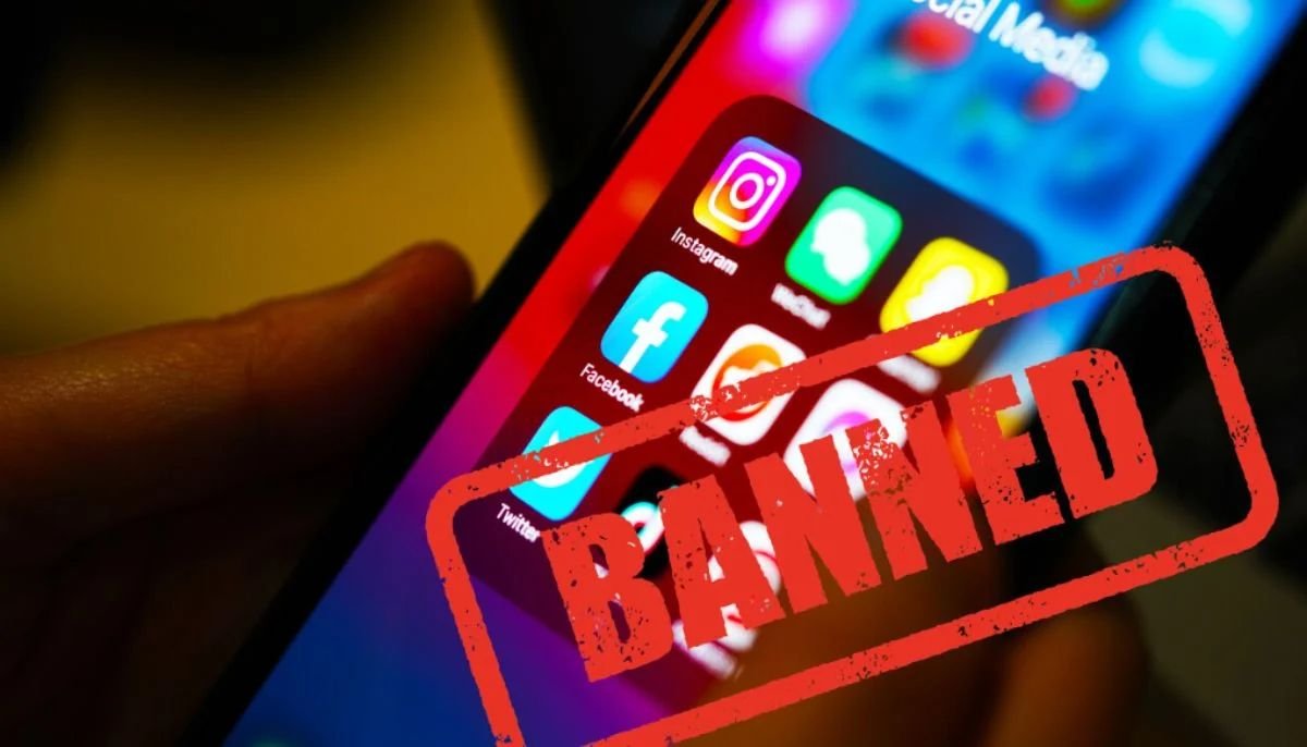 A smartphone full of social media apps stamped with a red BANNED label